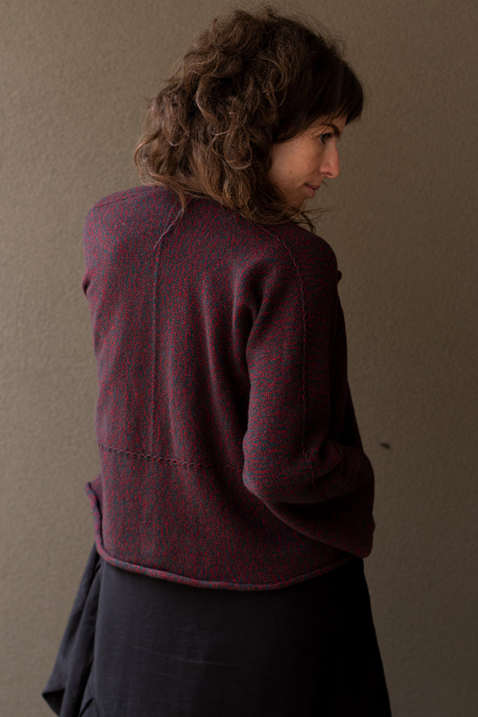 Back view of knitted wool cropped jacket in red and teal melange, designed by Wendy Voon, knitted in Melbourne.