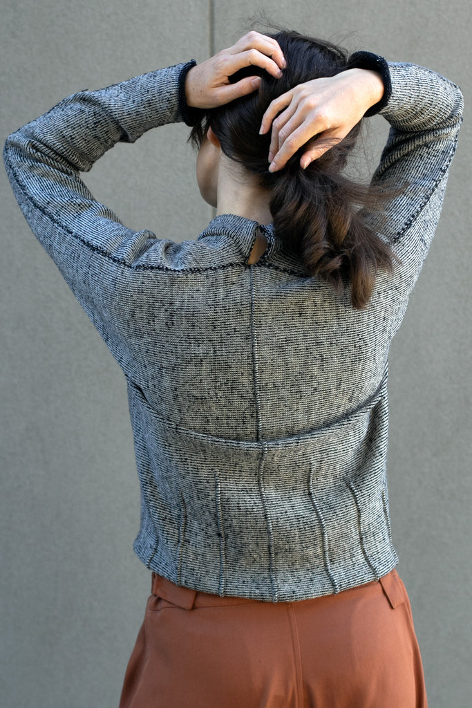 Back view of welted wool cardigan in cream, charcoal/black colourway